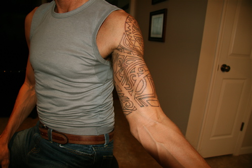 Red dragon cross tattoo on upper arm and Latin dragon cross tattoo design.